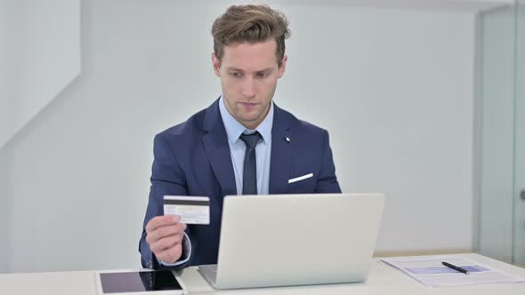 Focused Young Businessman Making Online Payment on Laptop 