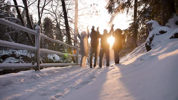 Group of Happy Friends Jumping in Winter Forest