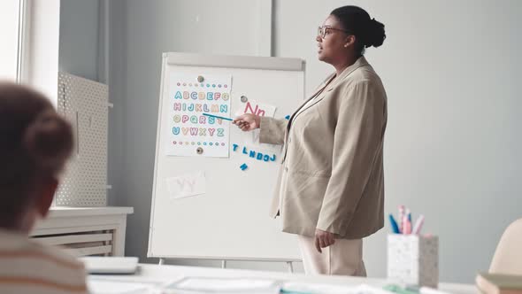 African-American Woman Teaching English Alphabet to Little Girl