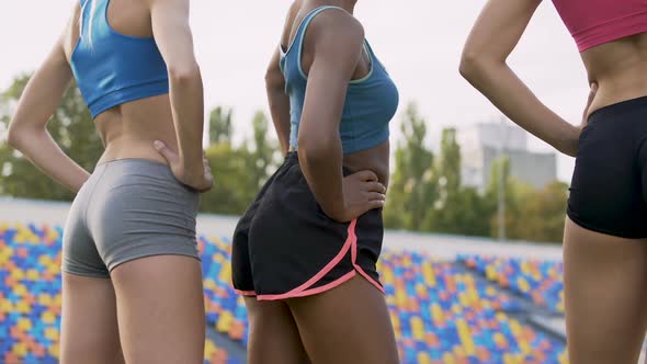 Mixed-Race Girls Doing Workout, Squatting and Warming up Muscles, Back View