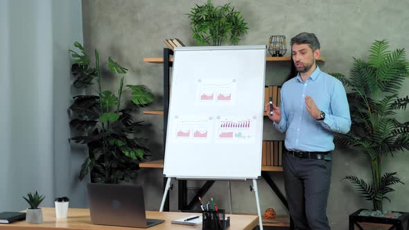 Businessman coach near flip chart talk teaches students online video call laptop