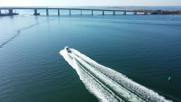 An aerial drone shot over Jamaica Bay in Queens, NY. The camera dolly in following a boat which head