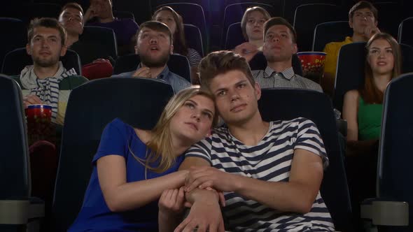 Couple of Lovers in the Front Row Watching a Movie at the Cinema