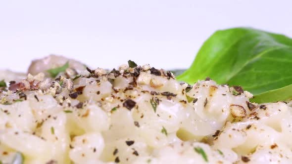 Close up view of homemade risotto covered with spices, macro shot in 4k, white background.