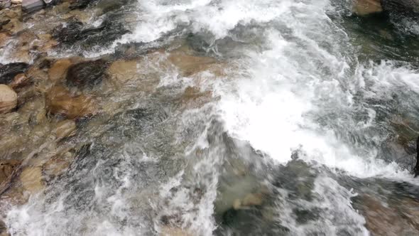 Moving closely over a quick current in a mountain stream with blue water