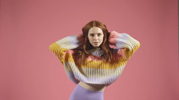 Model in the Studio Poses for the Camera a Portrait of a Redhaired Woman in a Pullover on an