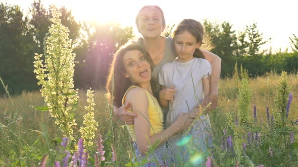 Cute Child Girl with Her Young Mother and Senior Grandmother are Having Picnic During Summer Outdoor