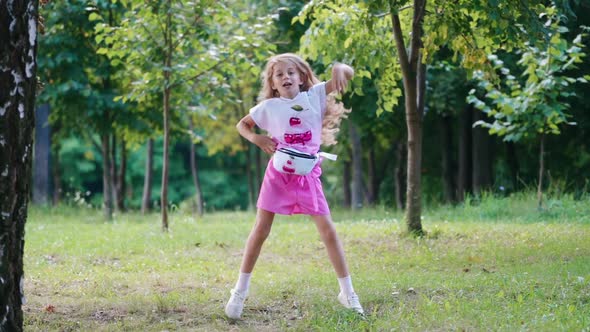 Girl dancing on the meadow. Happy girl having fun jumping outdoor at park