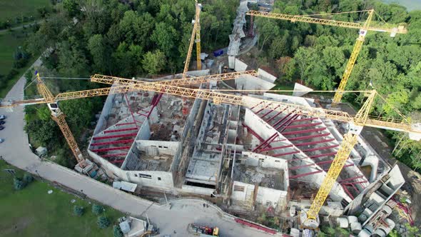 Aerial View Construction of a New Building with High Tower Cranes in Green Area