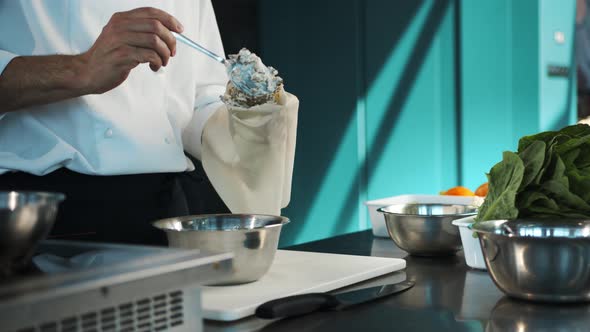Professional restaurant kitchen, close-up: The chef puts the sauce in the confectionery sleeve