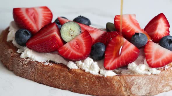 Toast with cream cheese, strawberries, blueberries and syrup