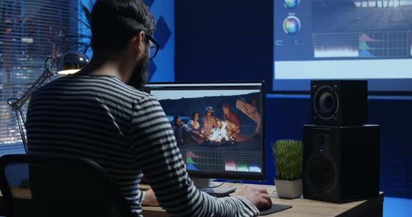 Young Man Sitting Back and Editing Video Inside a Room