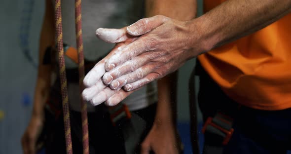 Man Rubbing His Hands with Chalk Powder at Bouldering Gym 4k