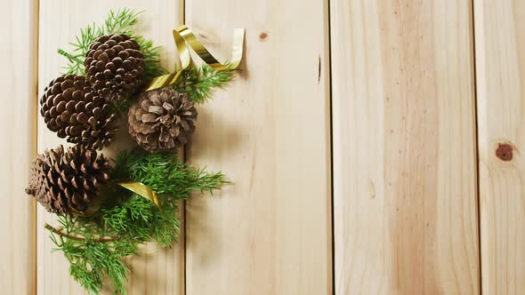 Video of christmas decorations with pine cones and copy space on wooden background