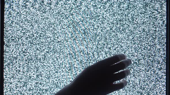 Human Hand Touching Old Retro Television Screen with Ripples Wavy Flowing Damaged Signal