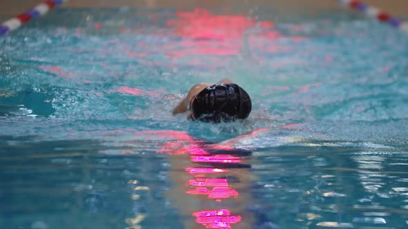 Young Man in Swim Glasses Training in the Pool