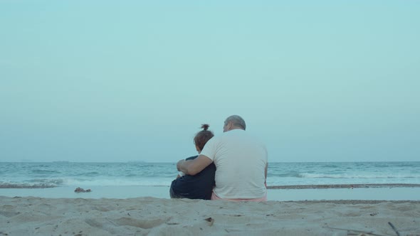 Grandfather and Grandson are Sitting on the Shore