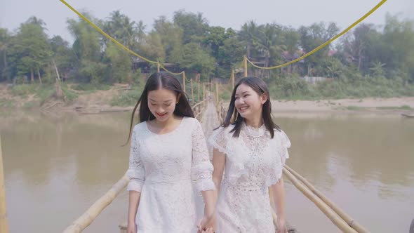 Two Asian Girls Happy Walking On Bamboo Bridge