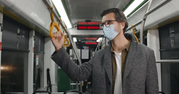 Crop View of Guy in Medical Protective Mask Coughing in Tram