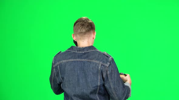 Back View of Man Walking Talking on the Phone and Drinking Coffee. Chroma Key