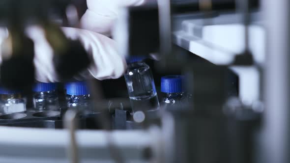 Scientist Puts Vial Into HPLC Autosampler at Laboratory