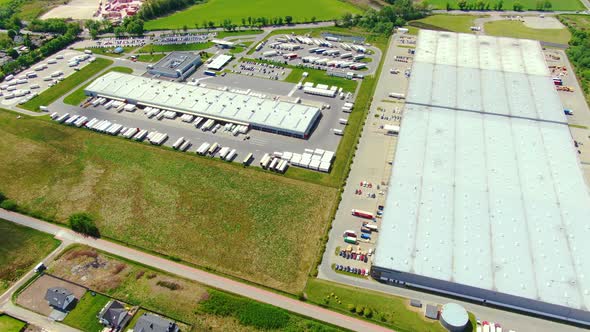 Trucks with semi-trailers stand on the parking lot of the logistics park with loading hub and wait f