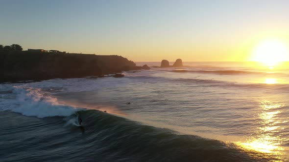 Aerial Shot: Epic Sunset surf in Punta de Lobos, pichilemu, chile. Surfer in the perfect Wave.