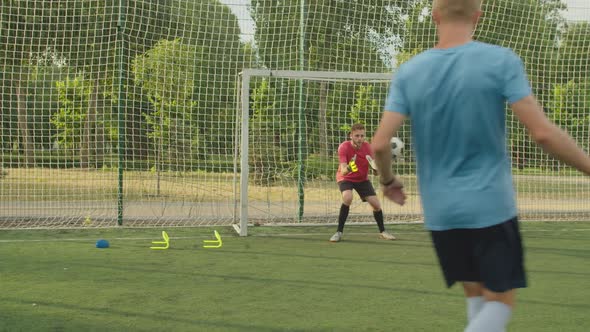 Compound Training of Soccer Goalie on Football Pitch at Daybreak