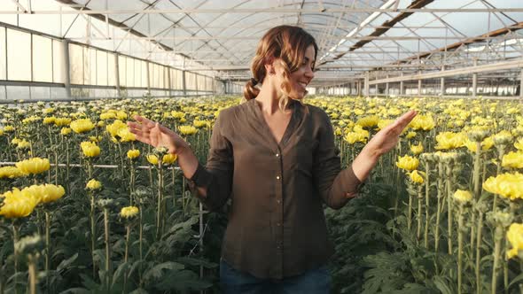 Pretty Woman Going Through an Indoor Plant