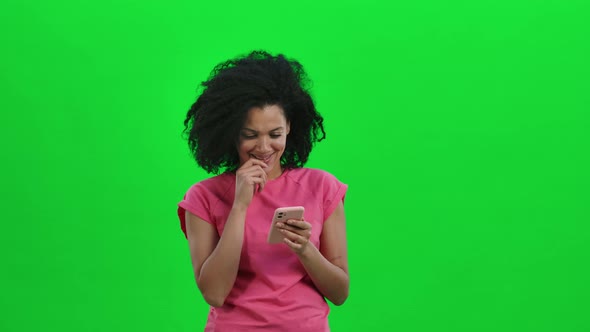 Portrait of Young Female African American is Texting on Her Phone and Rejoice