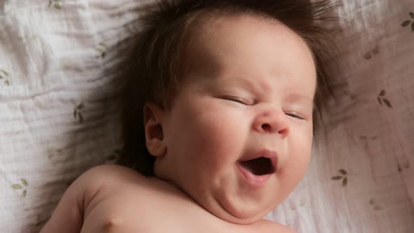 Cinematic video portrait newborn baby yawns, sleepy cute baby child.