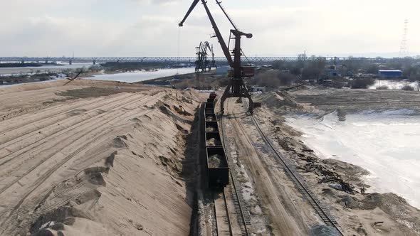 Loading Sand Into Rail Cars with the Help of a Career Excavator