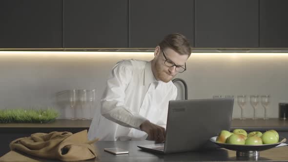 Successful Caucasian Man Pressing Button on Laptop Keyboard and Dollars Falling on Him From Above