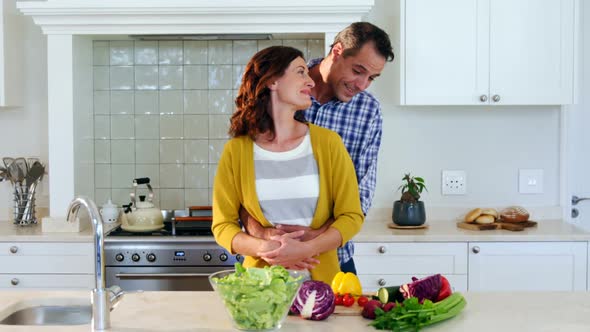 Couple embracing each other in kitchen