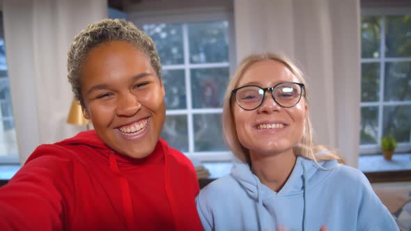 Two Beautiful Diverse Happy Girlfriends Taking Selfies or Recording Video for Blog on Social Media