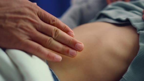 Doctor Hands Touching Stomach Closeup