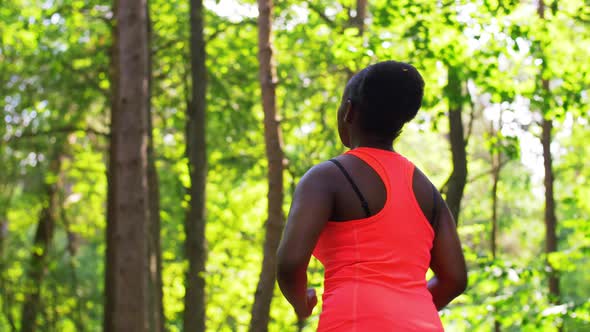 Young African American Woman Running in Forest