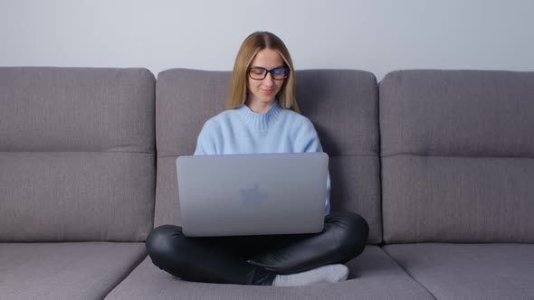 Entrepreneur business woman working on laptop computer on couch at home during lockdown in 4k video