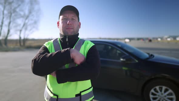 Portrait of Confident Caucasian Auto Instructor Crossing Hands and Looking at Camera