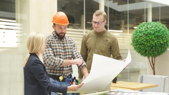 Team of Architects Working with Blueprints in Loft Office Discuss Building Design