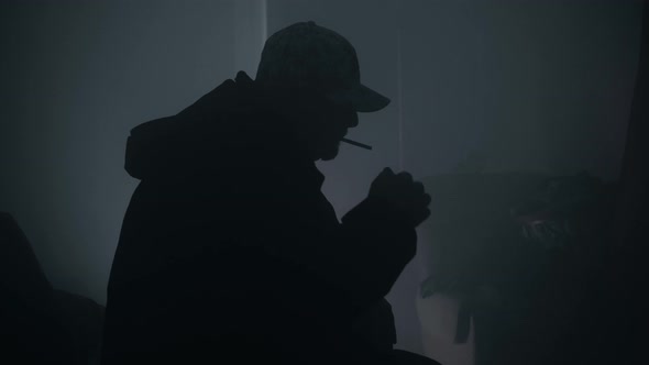 Silhouette Of A Man Lighting A Cigarette