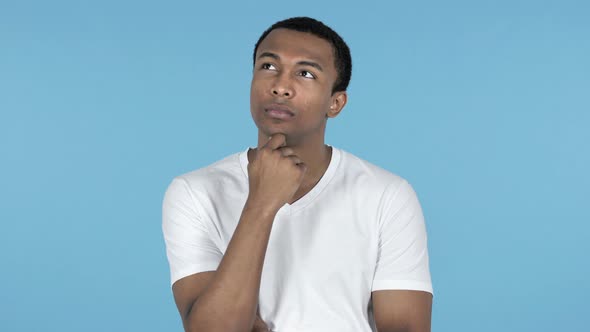 Pensive Young African Man Thinking, Blue Background