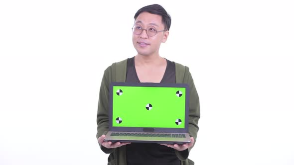 Happy Japanese Man with Eyeglasses Thinking While Showing Laptop