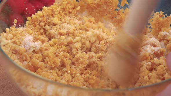 A Woman Blends Cookie Crumbs with Sugar in a Glass Bowl with a Pestle - Closeup