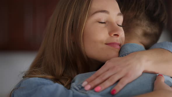 Closeup Portrait of Happy Smiling Young Woman Hugging Man Closing Eyes and Looking at Camera Smiling