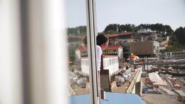 Young Woman in White Summer Dress Gazing at Beach at Sea From your Room Window