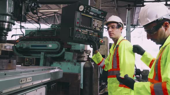 Group of Factory Workers Using Machine Equipment in Factory Workshop