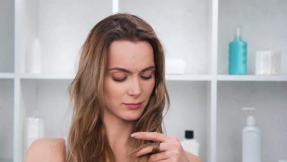 Closeup Portrait of Upset Beautiful Woman Touching Bad Condition Hair Posing at Bathroom  Footage