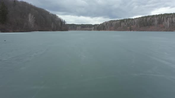 AERIAL: Low Flight Above Frozen Lake with Blue Colour Ice