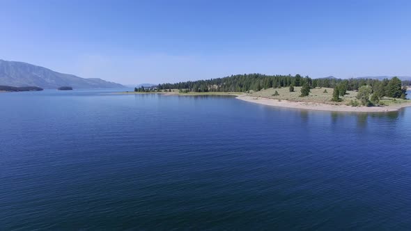 Camera flies low over Jackson Lake and then ascends as it approaches shore